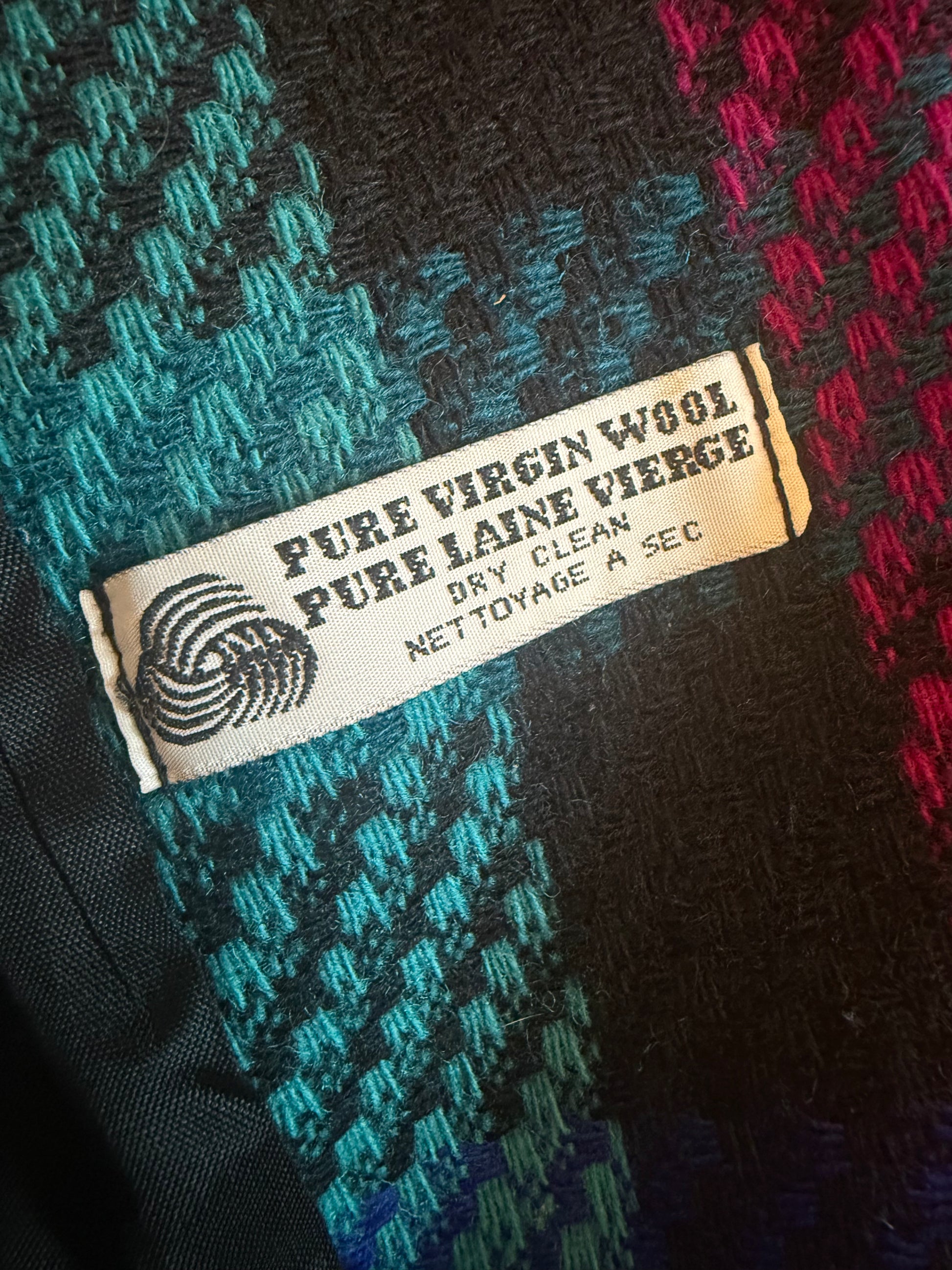 Label on a piece of fabric with 'Pure Virgin Wool' text and 'Pure Voyage' logo.