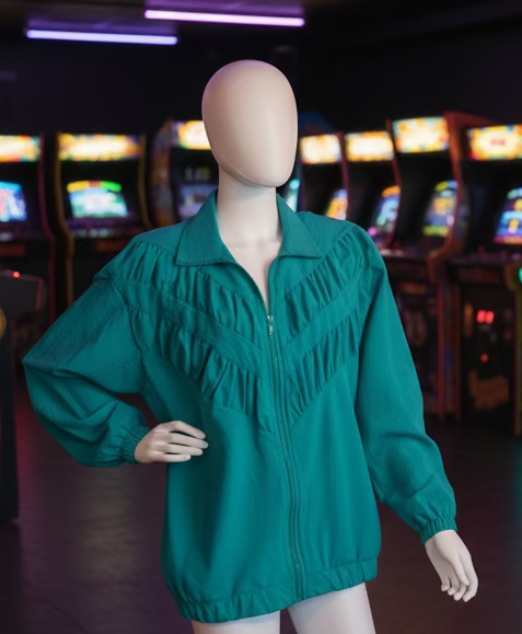 Mannequin wearing a teal blouse in a room with a poster on the wall.