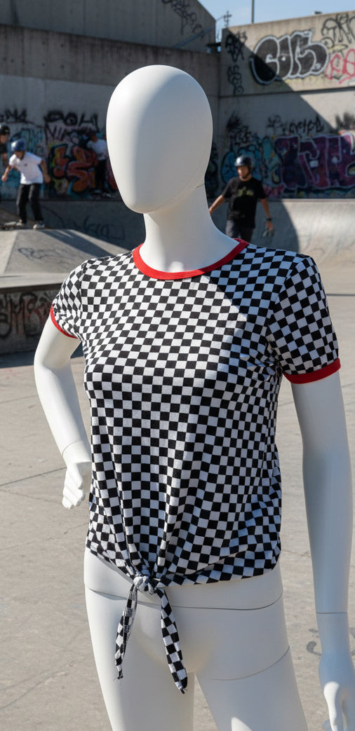Mannequin wearing a black and white checkered shirt with red trim at skate park 