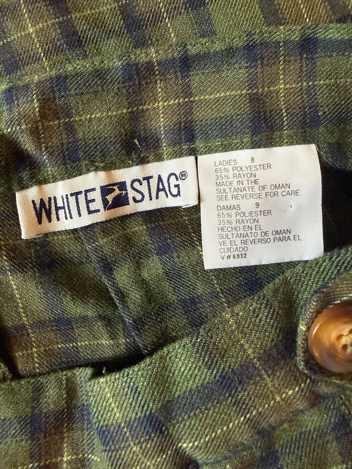 Close-up of a White Stag label on a plaid fabric background
