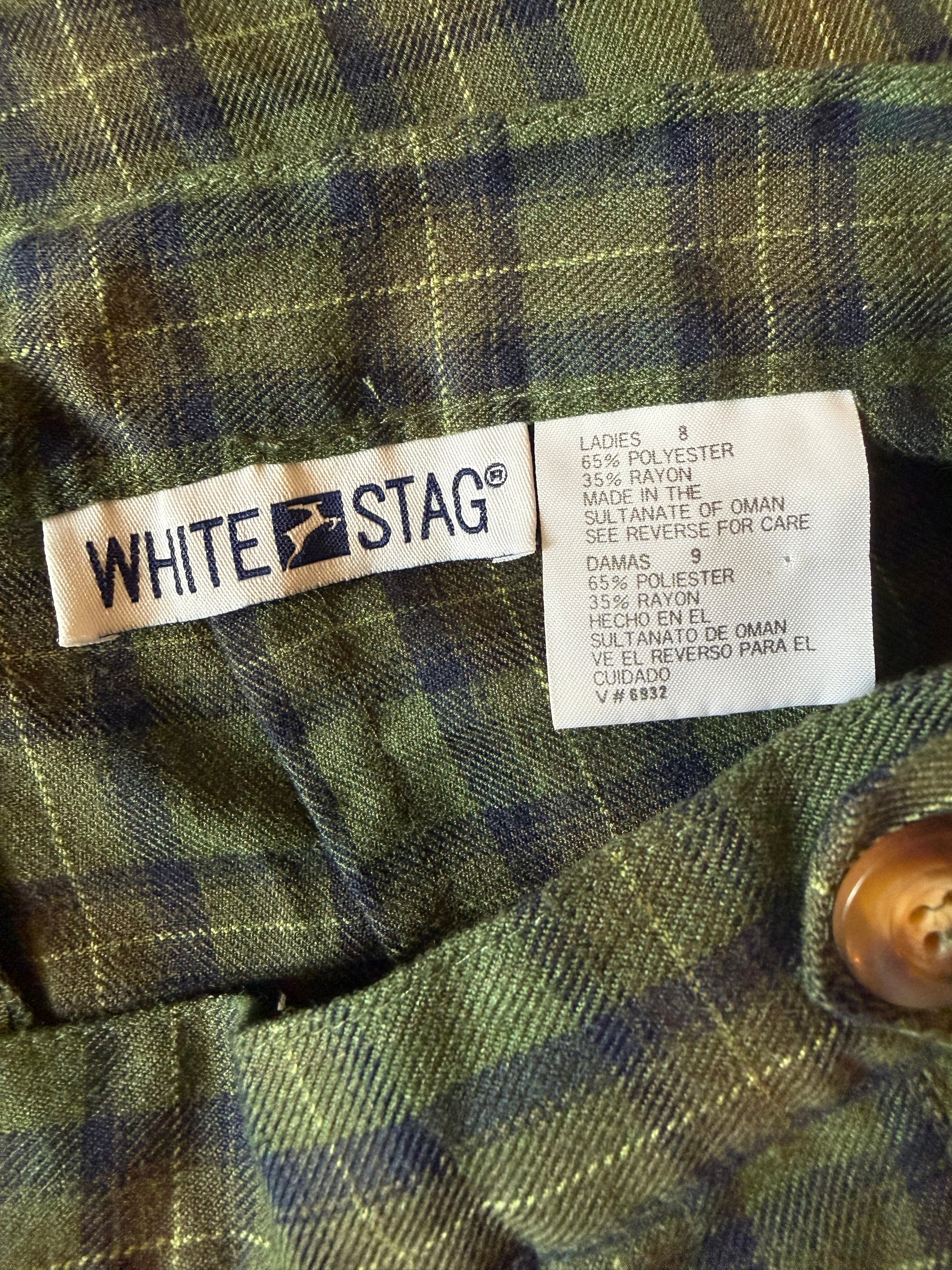Close-up of a White Stag label on a plaid fabric background