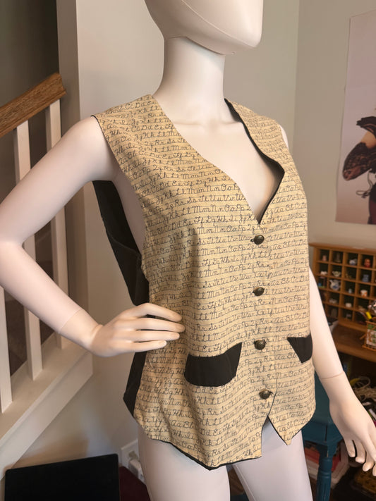 Mannequin wearing a vest with cursive alphabet. 